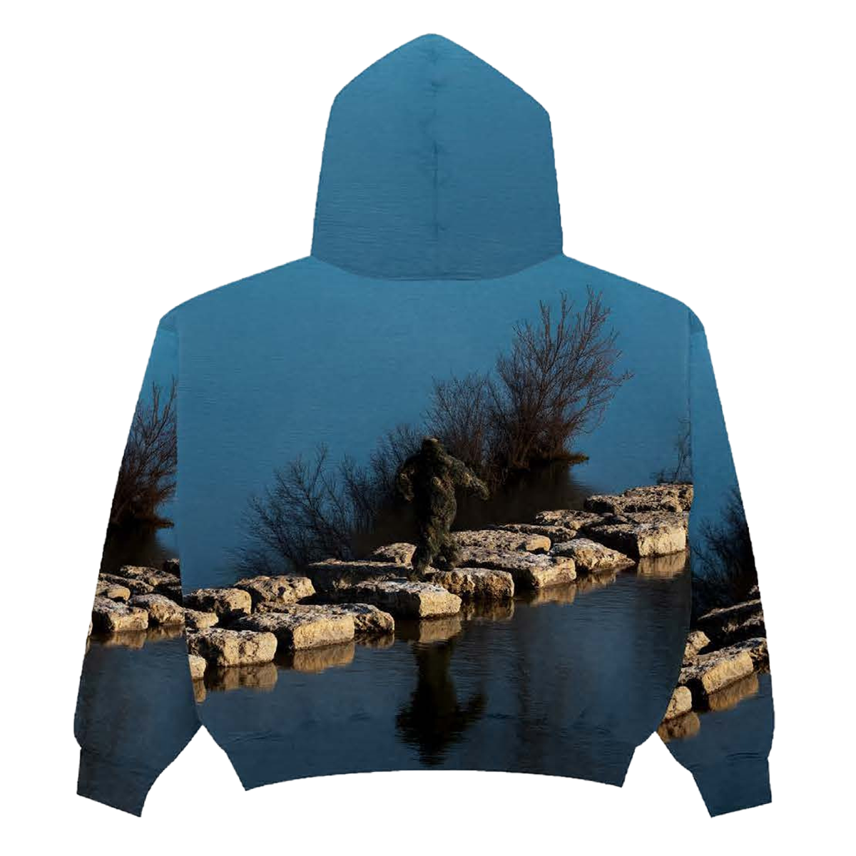 Back of a hoodie with a nature-themed design of a Sasquatch waking on rocks in between a lake on a blue background